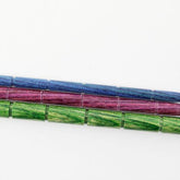 Three multi-colored Dreamz Cable Needles by Knitter's Pride from Accessories Unlimited are aligned horizontally on a white surface. The needles, made from densified laminated birch, showcase a segmented design with colors transitioning from blue at the top, to purple in the middle, and green at the bottom.