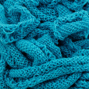 A close-up of a crumpled, loosely woven fabric from the Harrisville Potholder Loops - Traditional Size Mini Pack by Friendly Loom, showcasing its teal color, texture, and intricately interwoven fibers, reminiscent of designs crafted on a traditional loom.