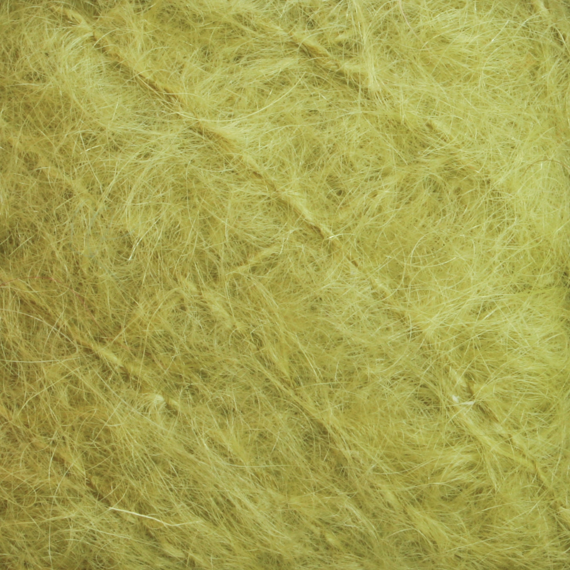 The close-up image showcases the luxurious texture of Caledonian Dye Works' Victorian Brushed Mohair Yarn in a large skein. The intertwined fibers form a dense, chaotic pattern, predominantly pale yellow with subtle shade variations, evoking the intricate quality reminiscent of classic Victorian yarns.