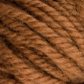 Close-up of thick, soft yarn tightly wound into a ball. The yarn is a warm, light brown color and shows a distinct, slightly fuzzy texture with clearly visible individual strands twisted together. Ideal for rug weavers, the Caledonian Dye Works Halcyon Yarn Classic Rug Wool | Strand has been hand-dyed to achieve its rich hue.