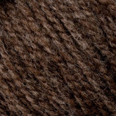 Close-up image of a textured brown yarn, showcasing the interwoven strands and fibers. The yarn, Bartletts Maine Wool - Sport from Bartlettyarns, appears soft and slightly fuzzy, with varying shades of brown giving it a rich, natural look.