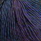 Close-up of a skein of Knitting Fever Painted Desert Yarn by Euro Yarns, featuring a rich mix of colors such as shades of purple, blue, and green, tightly twisted into strands. The texture appears soft and slightly fuzzy, showcasing a detailed and vibrant blend of hues with long color changes perfect for lightweight accessories.