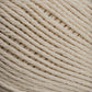 Close-up image of Brown Sheep's Cotton Fleece yarn in a beige hue, wound into a ball. The texture of the cotton fibers is distinctly visible, highlighting the tightly twisted strands and creating a consistent pattern of parallel lines. The soft pastels accentuate the yarn's intricate detail against an out-of-focus background.