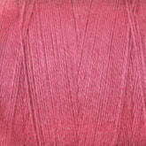 A close-up photograph of a pink spool of Maurice Brassard 8/2 Cottolin Organic Yarn, ideal for a Cottolin Tea Towel Kit. The image highlights the slight sheen and woven texture, showcasing fine, parallel strands tightly wound together. The consistent shade of pink is perfect for projects on a four shaft loom.