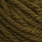 A close-up of a tightly coiled strand of Halcyon Yarn Classic Rug Wool from Caledonian Dye Works. The thick brown yarn reveals visible fibers with a slightly fuzzy texture and varying shades of brown, showcasing the depth and texture enhanced by traditional hand-dye techniques used by rug weavers.