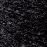 Close-up image of dark gray and black mixed Bartletts Maine Wool - Sport yarn by Bartlettyarns, showcasing the textures of the intertwined fibers. The sport weight yarn features a slightly heathered effect with subtle color variations, resulting in a rich, natural appearance.