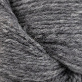 Close-up of a twisted skein of gray yarn, showcasing its soft, woolen texture and slight heathered appearance. The fibers are closely interwoven, highlighting the cozy, dense nature of the GOTS certified Patagonia Organic Merino by Juniper Moon Farm from Knitting Fever / Euro Yarns.