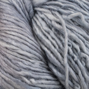 Close-up image of Malabrigo Silky Merino, a luxurious bundle of thick yarn from Malabrigo Yarn. The strands, loosely twisted together, reveal a textured and intertwined fibrous appearance with soft hues and subtle variations in tone.