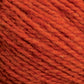 Close-up of an orange-colored Harrisville Shetland Yarn - Unwashed Cones by Harrisville Designs. The image showcases the texture of the yarn fibers tightly twisted together, clearly highlighting the strands and slight fuzziness typical of wool or a wool-blend material, often used in Fair Isle knitting designs.