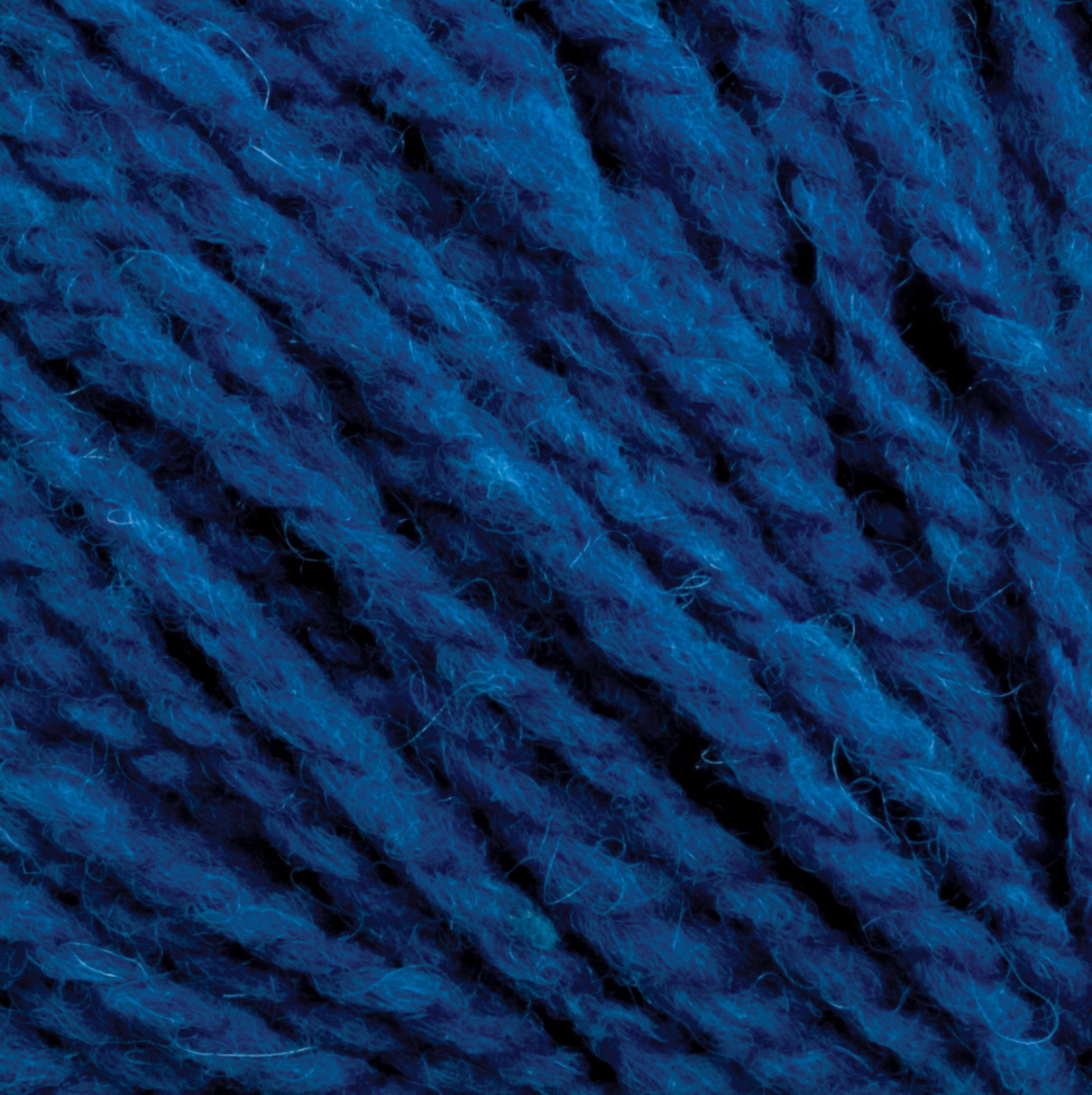 Close-up image of blue Harrisville Highland - Cones yarn by Harrisville Designs, showcasing thick, fluffy strands tightly twisted together. The texture is soft and fuzzy, with small loose fibers and visible spinning oils on the surface, indicating a plush material ideal for knitting or crocheting projects.