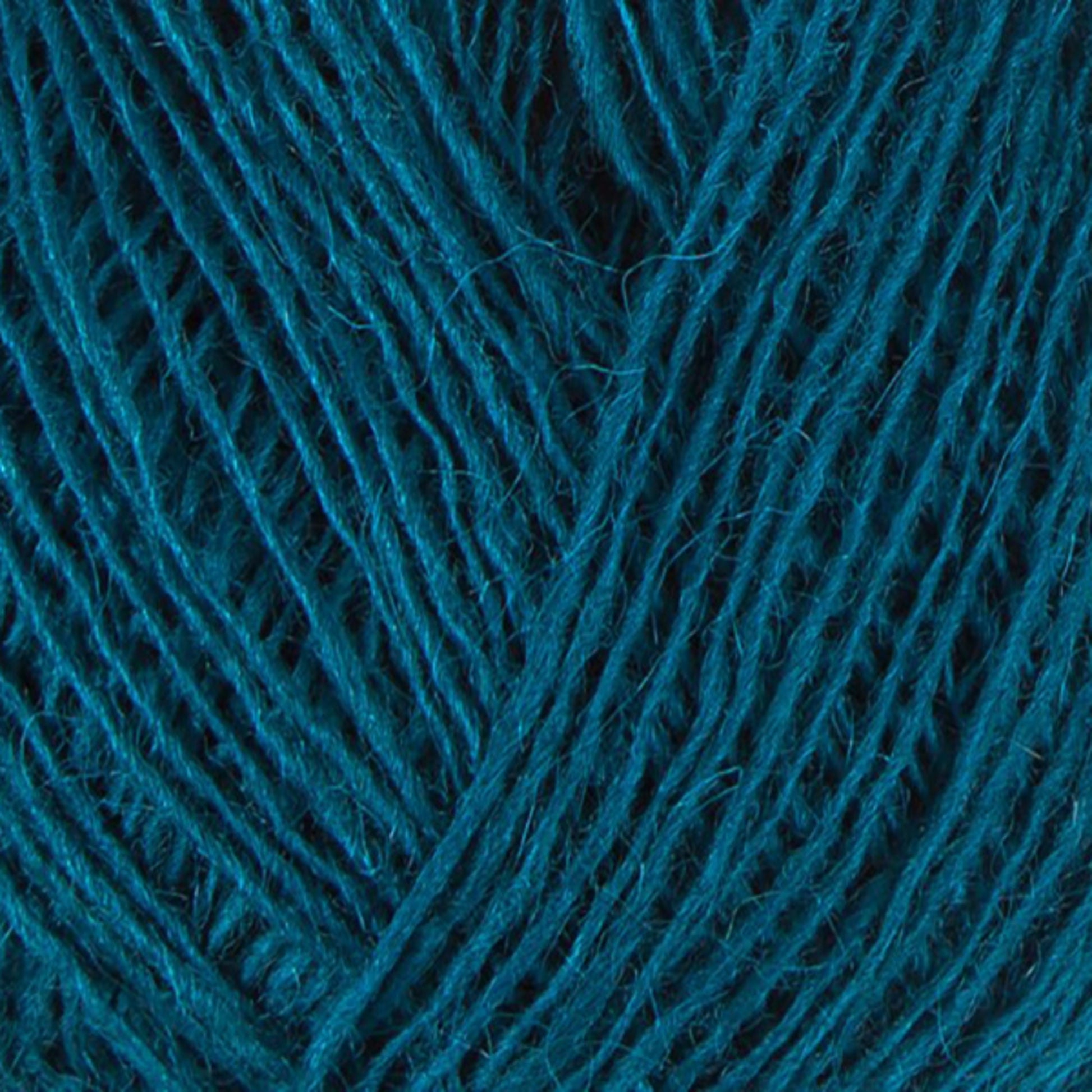 Close-up of a ball of teal-colored Einband Lopi yarn by Berroco, Inc., with tightly wound strands creating a textured appearance. The fibers appear soft and slightly fuzzy, enhancing the yarn's rich hue and complex texture, ideal for intricate lace knitting projects.