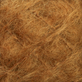 Close-up image of Victorian Brushed Mohair Yarn | Mini Skein from Caledonian Dye Works, showcasing a textured surface with a tangled mass of brown fibers. The fibrous material has a dense, interwoven appearance, resembling luxurious mohair or natural fibers.