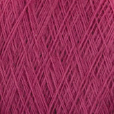 Close-up image of a ball of magenta-colored JaggerSpun Maine Line 3/8 Yarn from Jagger Brothers, Inc., showcasing the intricate crisscross pattern of the thick fibers. The texture appears coarse and woolly, emphasizing the quality of soft medium grade wool.