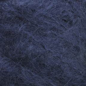 Close-up image of dark blue, fuzzy yarn. The texture appears soft and wooly, with fibers loosely intertwined and some stray strands, reminiscent of the luxurious Victorian Brushed Mohair Yarn in a large skein from Caledonian Dye Works.