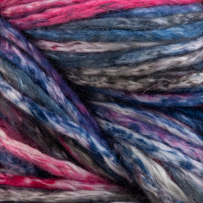 Close-up image of multicolored yarn. Cumulus Cotton by Juniper Moon Farm from Knitting Fever / Euro Yarns features a mix of pink, blue, white, and gray strands interwoven together, showcasing a soft and fuzzy texture. With durable chainette construction, the colors blend smoothly to create visually appealing, vibrant patterns perfect for weightless accessories.