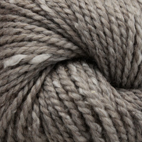 Close-up image of Acadia by The Fiber Company yarn twisted into a tight spiral. The yarn has a soft texture with subtle color variations and a slightly fuzzy appearance, showcasing the intricate details of its fibers, enhanced by a subtle tweed effect reminiscent of natural scenic beauty.