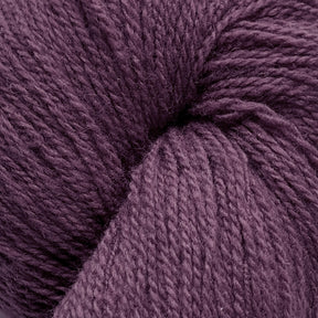 Close-up image of a skein of purple yarn. The yarn appears soft and textured, with tightly wound fibers creating a neat, round shape. Made from Patagonia Organic Merino by Juniper Moon Farm, a product by Knitting Fever / Euro Yarns, the rich purple color gives the yarn a vibrant yet cozy feel, suitable for knitting or crocheting projects.