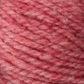 Close-up of a ball of Bartletts Maine Wool - Sport yarn with a soft, textured appearance. This sport weight yarn from Bartlettyarns features an inviting blend of pink and light red fibers, offering a cozy and warm feel.