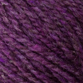 Close-up of a ball of Bartlettyarns' Bartletts Maine Wool - Sport, featuring a rich mix of purple and violet hues with strands of darker and lighter shades intertwined. The texture appears soft and slightly fuzzy, ideal for knitting or crocheting projects using this high-quality Maine wool.