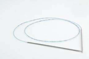 A slender, flexible medical or scientific tube with a long, translucent body and metallic ends is coiled on a white background. Reminiscent of Skacel’s Addi Turbo Circular Knitting Needles used in specialized procedures or equipment, the tube's precision mirrors that seen with these high-quality tools.