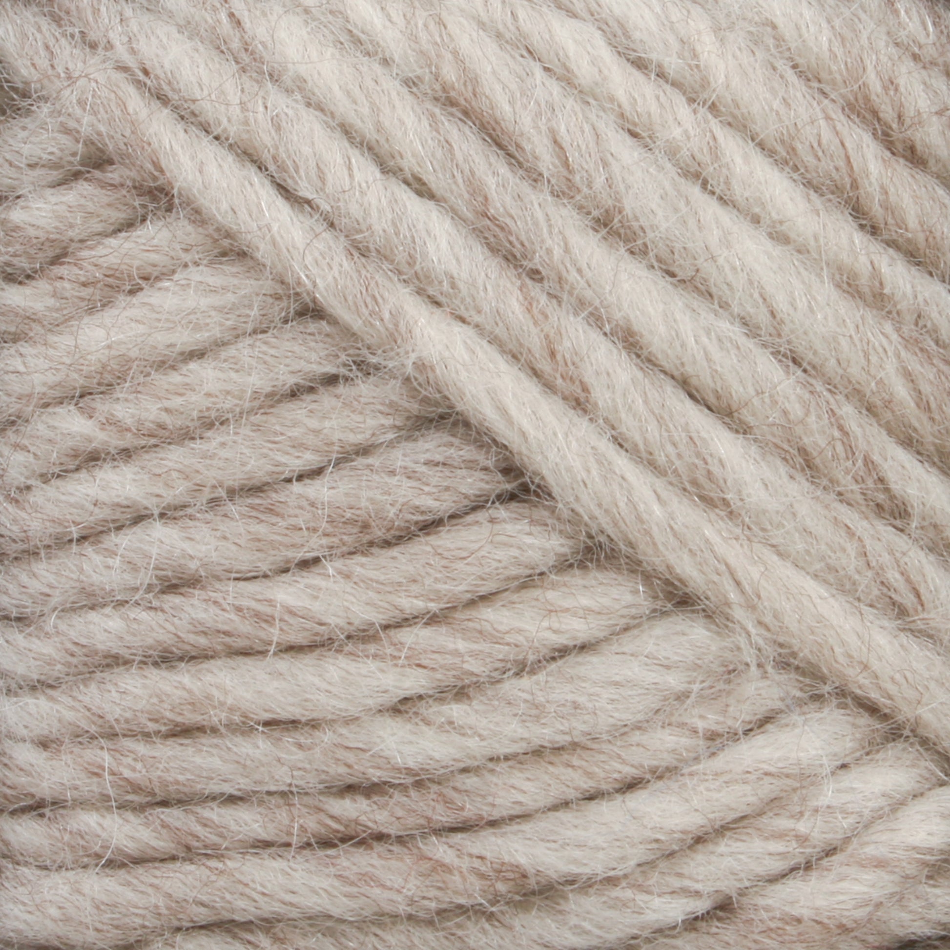 Close-up image of soft, thick, white and beige Lamb's Pride Worsted Yarn from Brown Sheep, coiled in a neat bundle. The slightly fuzzy fibers appear plush, suggesting warmth and comfort, ideal for knitting or crocheting winter garments or felting projects.