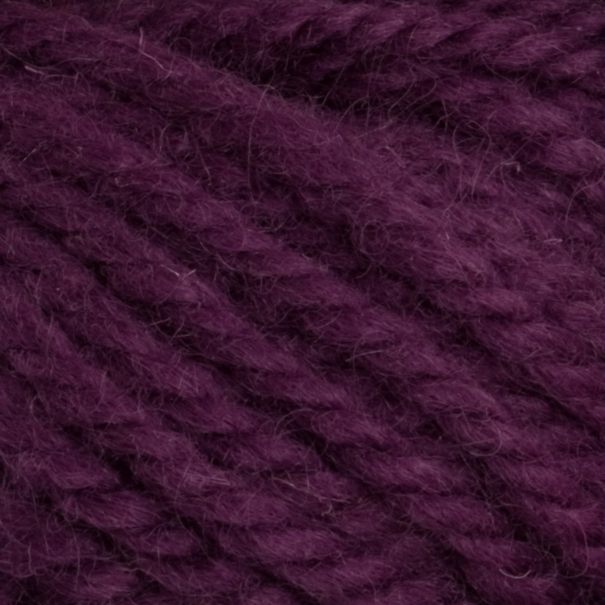 Close-up image of thick, textured Halcyon Yarn Classic Rug Wool in a rich, deep purple hue. The strands by Caledonian Dye Works are loosely twisted together, showcasing their fibers. The image highlights the yarn's softness and woven detail, perfect for weavers seeking high-quality Rug Wool.