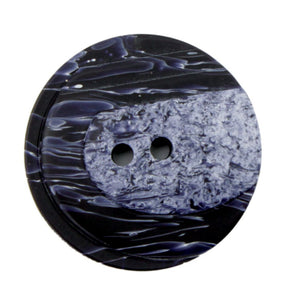 A close-up image of the Dill Buttons of America, Inc's Two Tone Button, which is a round, 1" button showcasing a marbled design. It features two-hole styling and exhibits a mix of dark and light swirls that create textured, two-tone shading. The contrasting colors form a unique and eye-catching pattern.