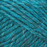 Close-up image of a ball of Lamb's Pride Bulky Yarn by Brown Sheep in teal, showcasing the intricate texture of the twisted fibers with interwoven strands of lighter and darker hues that create a rich, blended appearance. The yarn looks soft, thick, and slightly fuzzy—an ideal selection for knitters and crocheters creating cozy Icelandic sweaters.