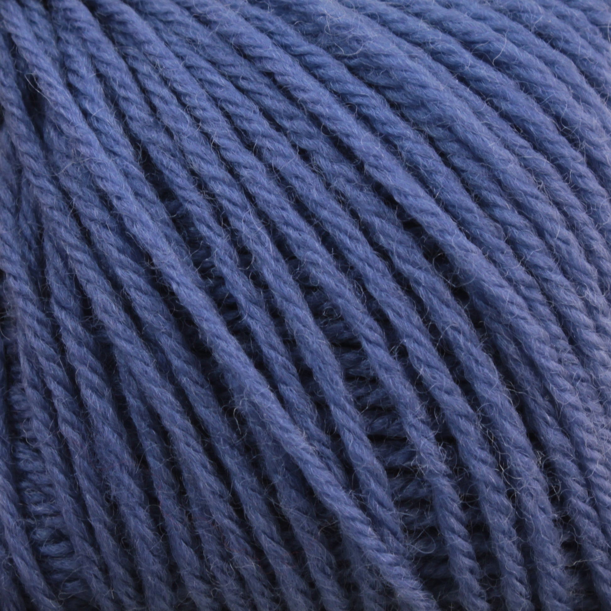 Close-up of Baby Blatt by Anny Blatt in blue, tightly wound into a ball, showcasing the soft and textured fibers in detail. This fingering weight, machine washable baby yarn from Essentially Felt Studio & Fine Yarn is perfect for delicate projects.