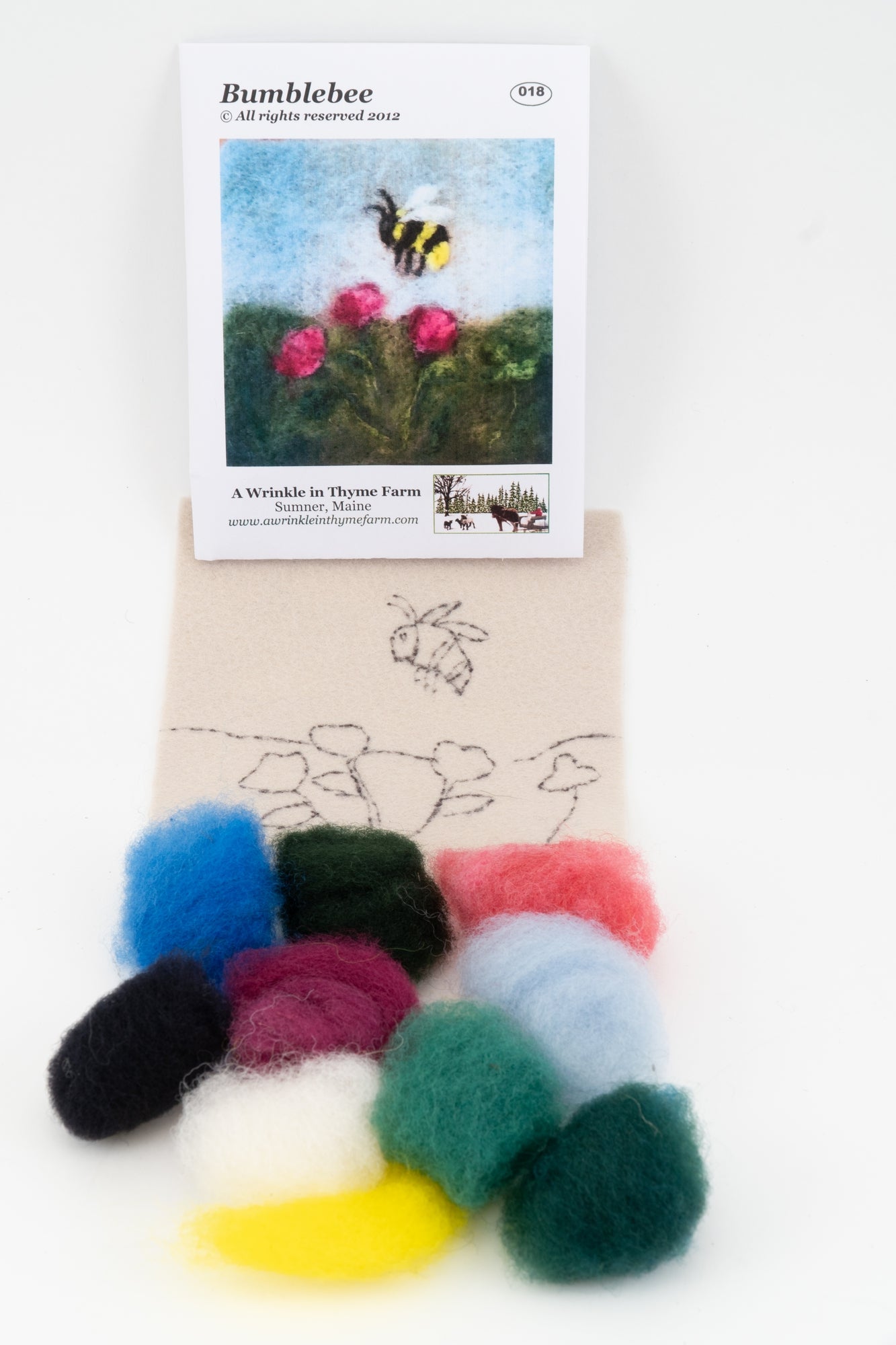 The Thyme Tile Felting Kit (no tools) by A Wrinkle in Thyme Farm is shown, featuring an image of a bumblebee on a flower. Below the image, colorful pieces of wool roving are arranged on fabric, including white, black, blue, green, purple, pink, red, and yellow. Perfect for beginner felters.