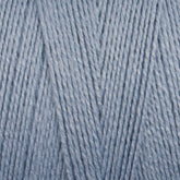 Here is a close-up of the Maurice Brassard 8/2 Tencel Yarn, Mini Cone in light blue. The yarn, known for its soft and smooth texture, has intricately wound strands that form a consistent and even surface. Ideal for weaving projects, it boasts a uniform color throughout and features a slightly glossy finish that reflects light beautifully.