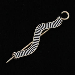 The Stripe Wavy Shawl Pin by Bonnie Bishoff Designs, from the esteemed Bonnie Bishoff brand, features an S-shaped design with alternating black and white stripes on a solid black background. This handmade gift includes a hook closure at the top and a needle-like part extending from the bottom, perfect for adding flair to knitted wearables crafted by local artisans.