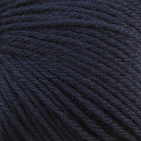 Close-up of a dark blue ball of Baby Blatt by Anny Blatt, showcasing the detailed texture of the tightly wound fibers. The yarn appears soft and slightly fuzzy with a rich, deep hue. This fingering weight yarn from Essentially Felt Studio & Fine Yarn is machine washable, making it perfect for delicate projects.