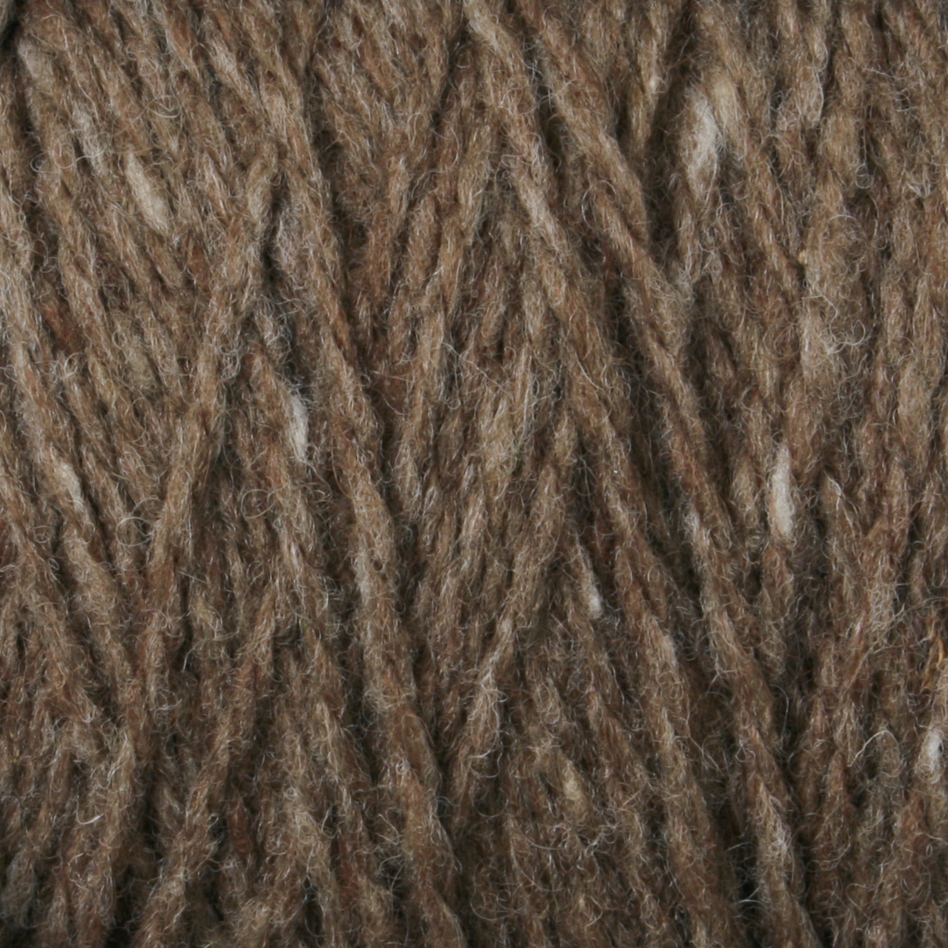 Close-up of twisted Harrisville Designs' Harrisville Shetland Yarn - Unwashed Cones with a slightly uneven texture, showcasing its fibrous and intertwined strands. The overall appearance is a rich, earthy brown with occasional lighter fibers interspersed throughout—ideal for Fair Isle knitting designs or lightweight blankets.