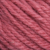 Close-up view of soft, pink yarn. The Halcyon Yarn Classic Rug Wool Skein by Caledonian Dye Works features a slightly fuzzy texture with fibers loosely twisted to form a thicker strand. The muted, dusty rose pink color highlights the intricate details of the yarn's strands and fibers—a true weaver's delight.