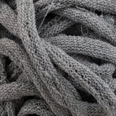 A close-up shot of a tangled mass of thick, gray fabric strands intricately intertwined together, reminiscent of traditional loom-woven cotton loops, showcasing the detailed texture of Harrisville Potholder Loops from the Traditional Size Mini Pack by Friendly Loom.