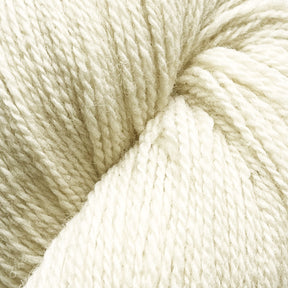 Close-up of a skein of Patagonia Organic Merino by Juniper Moon Farm, showcasing the detailed texture of the tightly twisted off-white fibers. The yarn, produced by Knitting Fever / Euro Yarns, appears soft and smooth, perfect for knitting or crocheting crafts. The image highlights the subtle variations in this sustainable yarn's fibers and color.