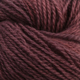 Close-up image of Jade Sapphire Cashmere 2-Ply yarn from Jade Sapphire Exotic Fibres, showcasing its dark brown color, texture, and twisted threads. The fibers appear soft and wooly, highlighting the material's thickness and uniform twist pattern—ideal for finely knit sweaters. The rich color remains consistent throughout the yarn.