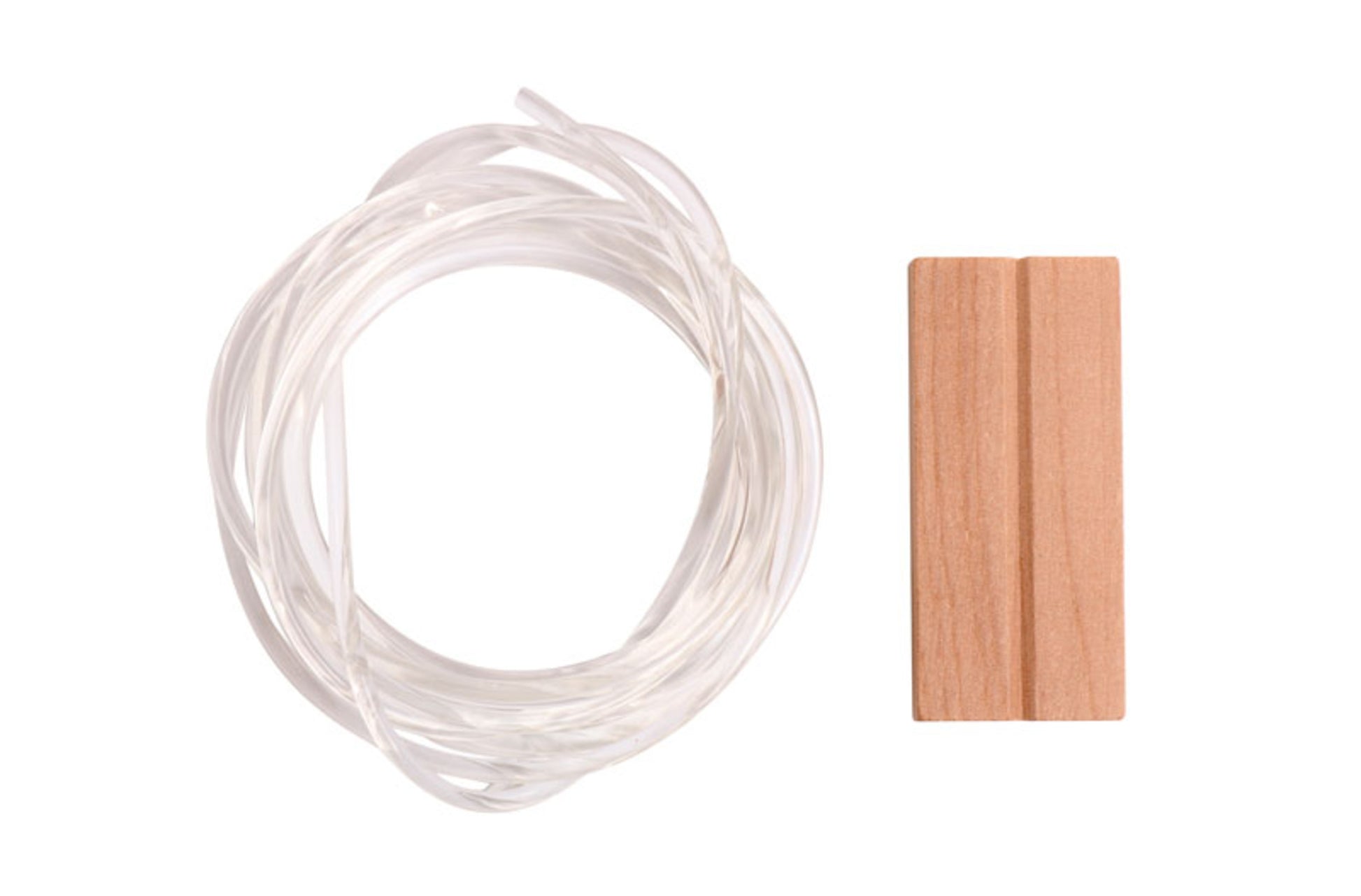 A coil of transparent fishing line is next to an Ashford Turbo Kit Polycord drive band, a small, rectangular wooden object with two parallel grooves running along its length. The items are placed against a plain white background.