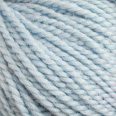 Close-up image of light blue Norumbega yarn by Caledonian Dye Works, showcasing the soft, twisted fibers. The yarn appears thick and fluffy, with slight variations in the shade of blue and a hint of fuzziness along the strands. Made from 100% U.S. wool, it promises a durable fabric for your crafting needs.