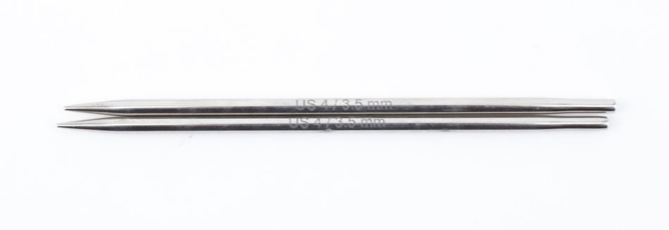 Two sleek, double-pointed metal knitting needles, resembling hollow brass pipes, are laid together on a white background. One needle features an engraved measurement reading "US 4 / 3.5 mm," highlighting the craftsmanship of Accessories Unlimited's Nova Platina Interchangeable Knitting Needles, 4.5" Tip.