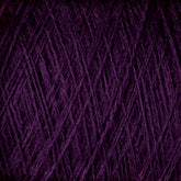 Close-up image of a bundle of dark purple JaggerSpun Maine Line 3/8 Yarn | Mini-cone from Jagger Brothers, Inc., showcasing the texture and intertwined strands typical of Maine wool yarns. The dense, fibrous pattern reveals rich, deep colors with threads overlapping in various directions.