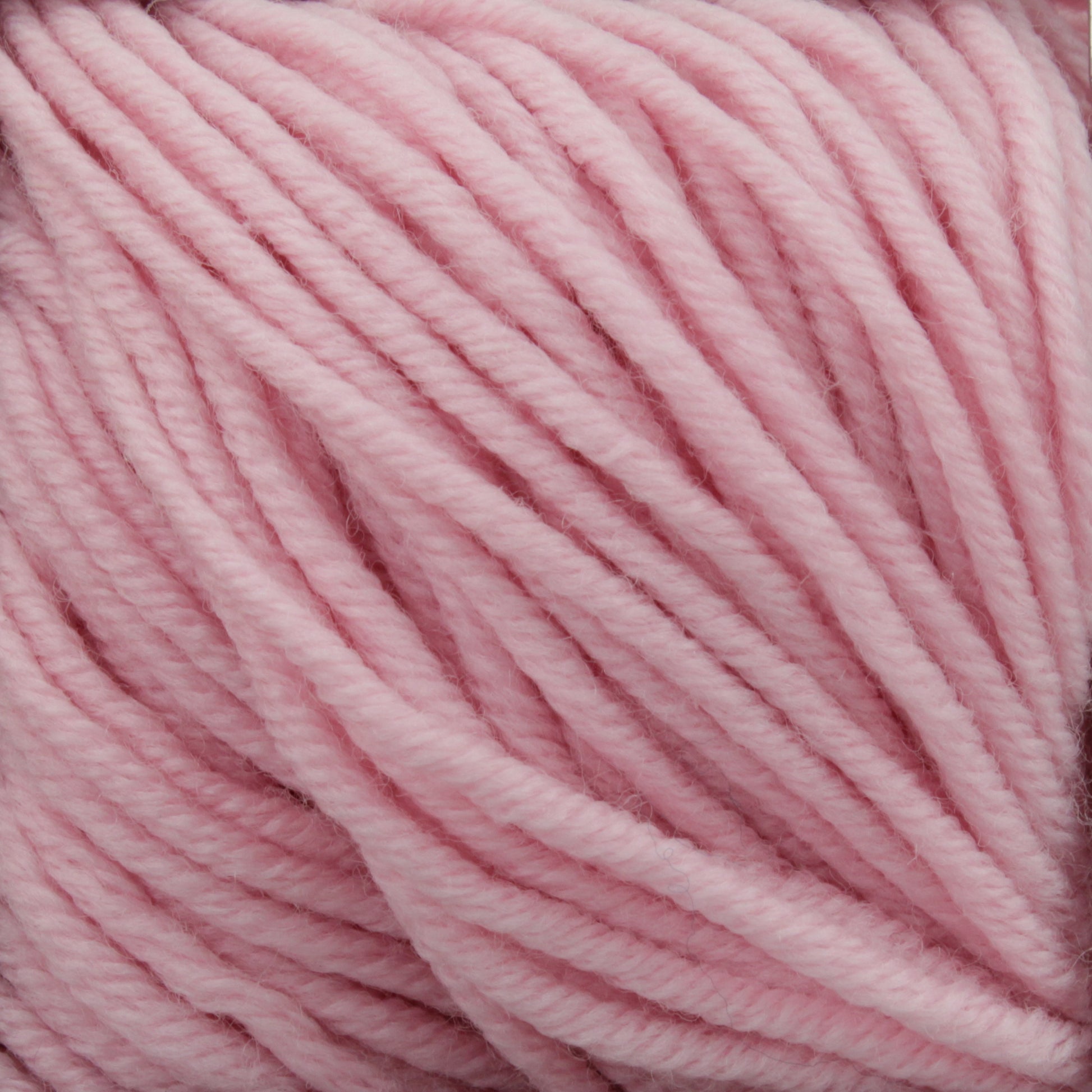 Close-up image of Plymouth Select Worsted Merino Superwash yarn by Plymouth Yarn Co. The soft, light pink merino strands are slightly twisted and have a smooth, fuzzy texture. The yarn appears thick and is neatly coiled, indicating it's ready for knitting or crocheting projects with excellent stitch definition.