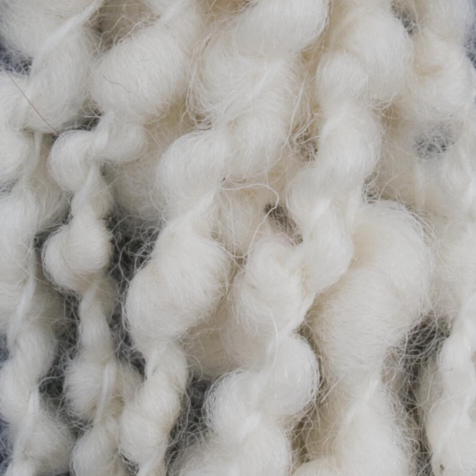 Close-up of soft, chunky Polar Bear Yarn from Henry's Attic with thick, twisted strands. The fibers appear fluffy and loosely spun, creating a cozy, textured appearance. Perfect for knitting or using with a 4-6 dent reed as an accent in the warp of your weaving projects.