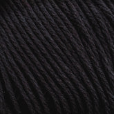 Close-up image of tightly wound, dark-colored Cotton Fleece by Brown Sheep, showing the detailed texture and strands of the material. The color appears to be a deep black, highlighting the twists and fibers in the yarn, making it perfect for intricate knitting patterns.