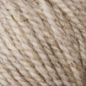 Close-up of beige and cream twisted yarn fibers. The texture is soft and fluffy, with a mixture of thick and thin strands. Made from Bartlettyarns Maine Wool - Sport, this yarn has natural fibers that give it a slightly uneven, rustic appearance enhanced by subtle heathered colors.