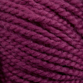 Close-up image of a skein of dark magenta Norumbega yarn made from 100% U.S. wool by Caledonian Dye Works. The strands are thick, tightly wound, and slightly fuzzy, revealing a soft texture. This vibrant Aran weight yarn is perfect for creating durable fabric in your knitting or crocheting projects.