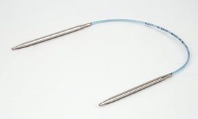 A pair of Skacel's Addi Turbo Circular Knitting Needles with silver-colored pointed tips are connected by a flexible blue plastic cable. The needles are arranged in a curved shape against a white background, making them perfect for knitting cuffs, collars, or doll clothes with ease and precision.