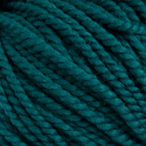 Close-up image of tightly wound, teal-colored Norumbega Aran weight yarn strands from Caledonian Dye Works. The texture showcases the 100% U.S. wool's soft and slightly fuzzy surface, twisted into thick, consistent ropes. The overall appearance is vibrant and richly hued.