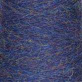 A close-up shot of Jagger Brothers, Inc.’s JaggerSpun Heather 3/8 in blue, with subtle hints of purple and green woven throughout. The fibers are intertwined tightly, showcasing a rich and textured surface. This wool yarn has a fluffy appearance with fine strands visible throughout.